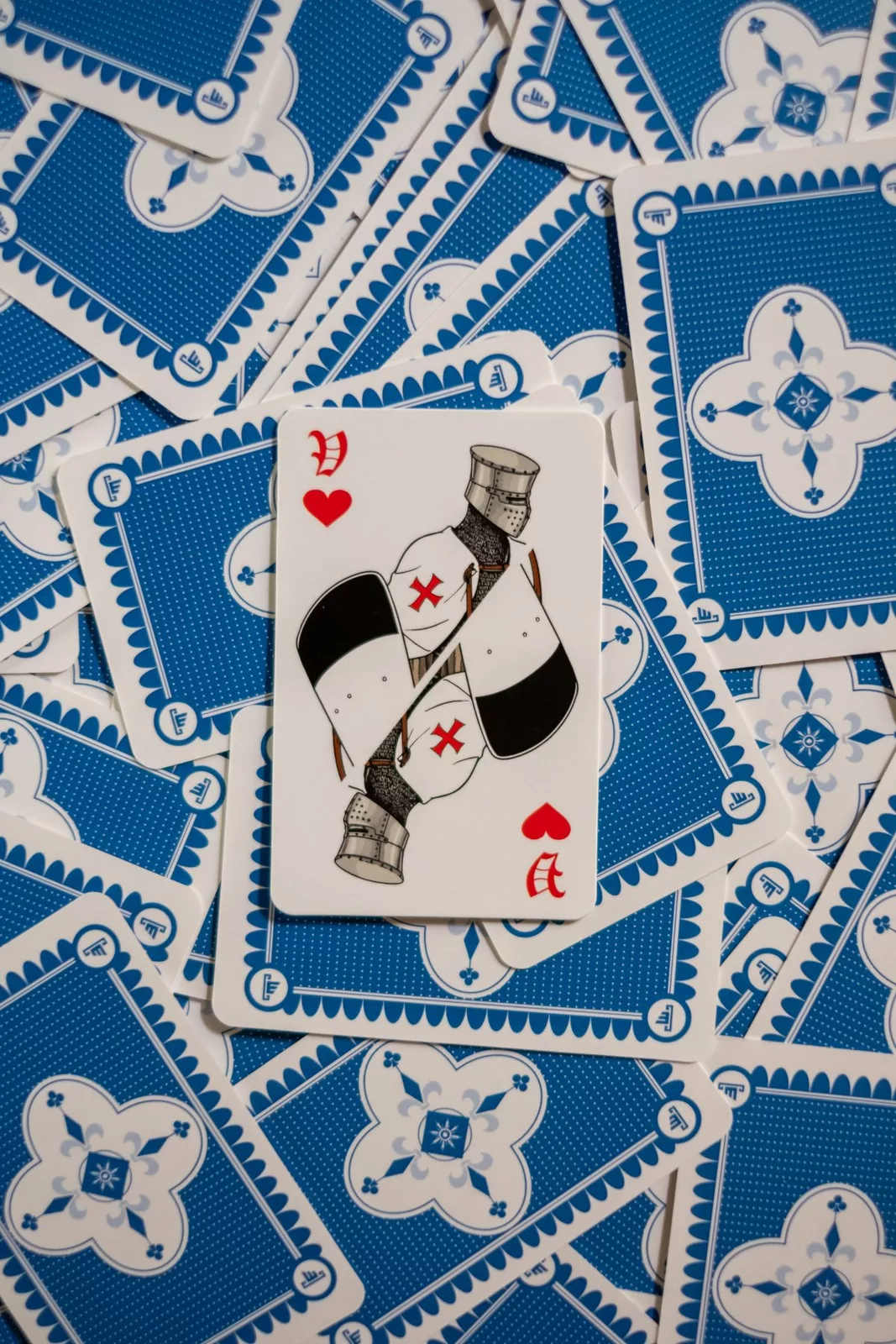 Une figure des Rois de France, un chevalier à la croix rouge, posée sur des cartes à dos bleu